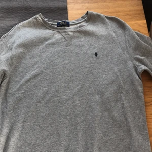 Ralph Lauren - College/Sweater från Ralph Lauren. Grå med blått monotyg Passar S