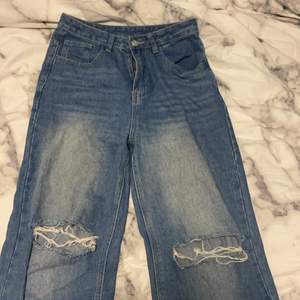 Ett par baggy jeans med hål i som är jätte enkla att styla med. Dom sitter lite tightare där uppe och blir luftigare längre ner. 