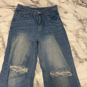 Baggy jeans - Ett par baggy jeans med hål i som är jätte enkla att styla med. Dom sitter lite tightare där uppe och blir luftigare längre ner. 