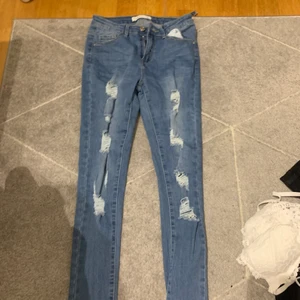 Jeans - Blåa slitna jeans. Storlek 36. Ett tygbit gått av som man ser till vänster men går att fixa. Annars jättebra skick. Jag kan mötas i Stockholm. Och även posta men ni står för frakten❤️
