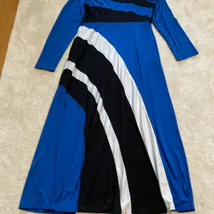 En vit svart och blå klänning som är lång armad, den har endast användes ett få tal gånger och är i storlek XL 