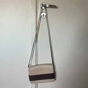 Beige axelväska  - Säljer denna axelväska som jag köpte på H&M i Schweiz för många år sedan. Säljer pågrund av att den inte kmr till användning. Den är så gott som ny.  (Köpare står för frakt)