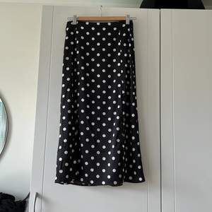 Svart prickig H&M kjol med två slits, i storlek 34. Har använt den några gånger men är i väldigt fin skick. Säljer eftersom den inte passar längre.