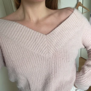 Stickad tröja  - Ljusrosa fluffig, stickad tröja från Divided i storlek S. Superfin djup/bred v-ringning. Lite kortare modell (slutar ungefär vid naveln), med smickrande passform😻