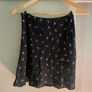 Stretchig kjol med blommor - Kjolen har dubbelt tyg så den är inte genomskinlig. Har dragkedja i sidan så passar allt ifrån xs-m beroende på hur man vill att den ska sitta. Slutar mitten på låret på mig som är 166 cm. Aldrig använd! Hör av dig för fler bilder eller vid frågor😊