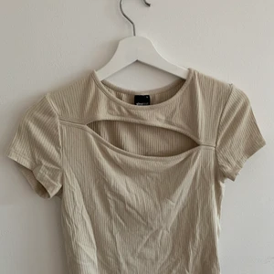 Croppad topp - Croppad topp i färgen beige. Aldrig använd. Fint skick.