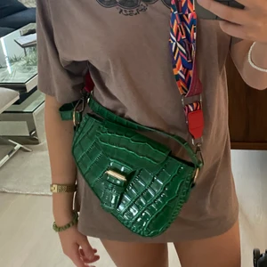 Grön” krokodil”  väska - Säljer denna krokodil liknande väskan som jag köpt på plick men kom inte till min användning! Så hoppas någon annan kan ta användning för den, skriv privat för mer info!