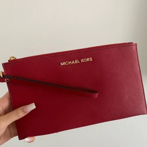 Michael Kors Clutch - Röd Michael Kors clutch köpt från NK i Göteborg, Helt ny/i Nyskick, Aldrig använt säljes därav