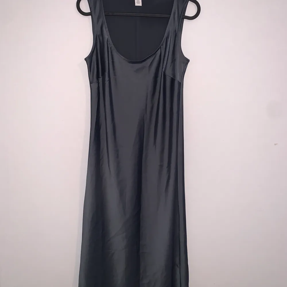 Sleek and shiny dark blue-grey Calvin Klein dress, in between a midi and a maxi this dress is super flattering and comfortable. Superficial damage on the right bum area, (photo 3) hardly noticeable in normal light , fits as a size small. Klänningar.