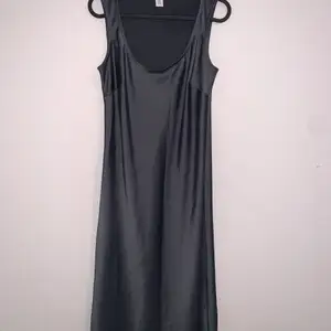 Sleek and shiny dark blue-grey Calvin Klein dress, in between a midi and a maxi this dress is super flattering and comfortable. Superficial damage on the right bum area, (photo 3) hardly noticeable in normal light , fits as a size small