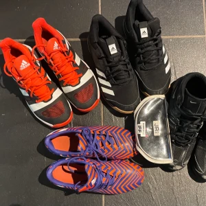 Innebandy och fotbollsskor och glasögon  - Fotbollsskor Adidas orange/blåa Stl 37 1/3.  Dobbar ngt slitna annars i fint skick 75:-    inneskor svart/vit/orange Adidas 37 1/3 mycket fint skick (ett litet märke) 150:-  inneskor svarta Adidas med vita ränder 38 1/2 använda 3 ggr 200:-  Innebandymålvaktsskor Nike, något slitna Stl 37,5 (nötta framtill) 75:-   Innebandyglasögon Unihoc Junior svarta med rosa detaljer inkl fodral 100:-  Kan skicka, köparen betalar frakt. Finns på Värmdö