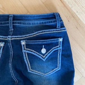 Bootcut jeans - Jag säljer dessa snygga bootcut jeans med knappar på bakfickorna! Inga slitage över huvud taget och är inprinsip nya, köparen står för frakt