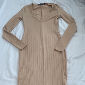 Lång klänning  - Säljer denna jättefina beigea klänningen från boohoo med en slits där nere på baksidan och som är urringad. Jättefin nu till sommaren. Storlek 34 