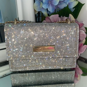 River Island Bling Väska  - Knappt använd River Island Väska i grå och bling kan man väl säga. Axelbandet är långt. ✨✨✨