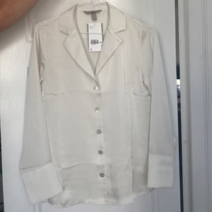 Vit sidenskjorta - En vit sidenskorta från H&M. Har aldrig använts och har lappen kvar.   Storlek S.