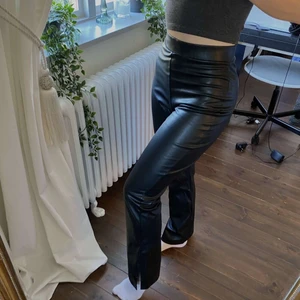 Skinn byxor - Utsvängda skinn byxor med slits nertill