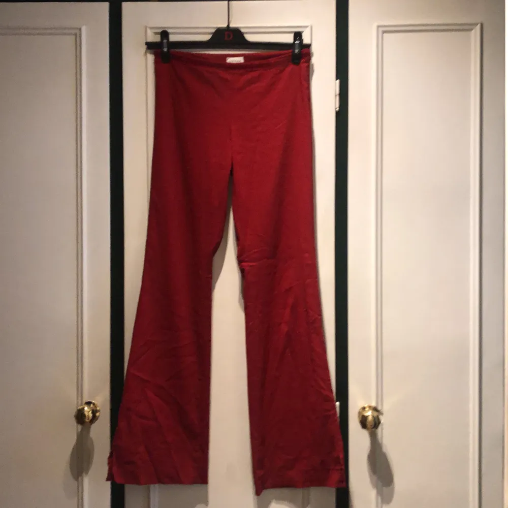 Sköna lite utsvängda röd röda byxor med paljettkant. Jeans & Byxor.
