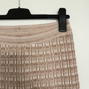 Beiga loungebyxor - Beiga och vita loungebyxor med utsvängda ben. Byxorna kommer från H&M och är i storlek S. I väldigt gott skick.