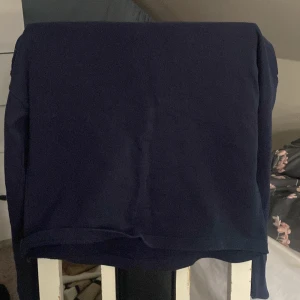 Svart tröja med vit och röd vid armarna - En svart tröja utan luva med vit och röda streck vid armarna 