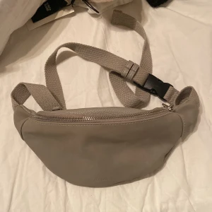 Väska - Crossover väska från dondonna i en grå beige färg, praktiskt och fin använd vid 3 tillfällen 