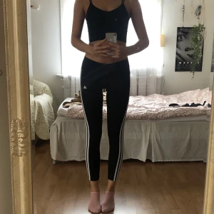 Adidas tights - Säljer dem här svarta adidas tightsen med vita ränder på vardera sida.