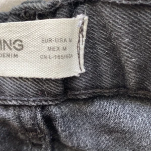 Storlek M - En skön jenas kjol. I färgen ljus svart. Rätt så kort i längden. Sitter över magen.