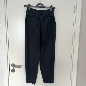 Mörk blå kostymbyxor - Snygga kostymbyxor i mörk blå! Materialet är väldigt mjukt och byxorna sitter väldigt bekvämt (jag är 175 cm lång). Har använts fåtal gånger. Ingen retur. Alla plagg som säljs tvättas noga innan leverans! Det är bara att skriva om du har några frågor eller vill se fler bilder på plagget! <3