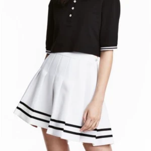 Vit kjol - Vit veckad skaterskirt med svarta ränder längst ner som går att sprättas bort om önskas.