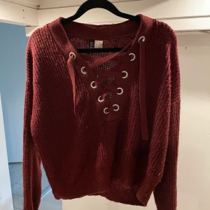 Stickad tröja - Stickad tröja med knytning där fram i härlig vinröd färg, perfekt nu till hösten!