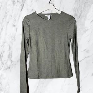 Topp | Nelly - Långärmad topp från nelly. Använd få gånger, bra skick. Skulle säga att färgen är lite grå/grön 