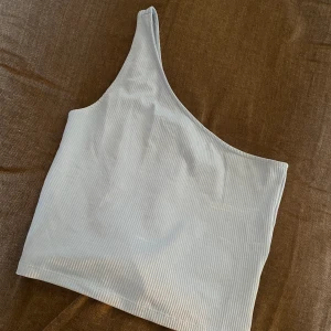 Blå topp - Snygg one shoulder topp från gina (slutsåld) sparsamt använd så i nyskick!