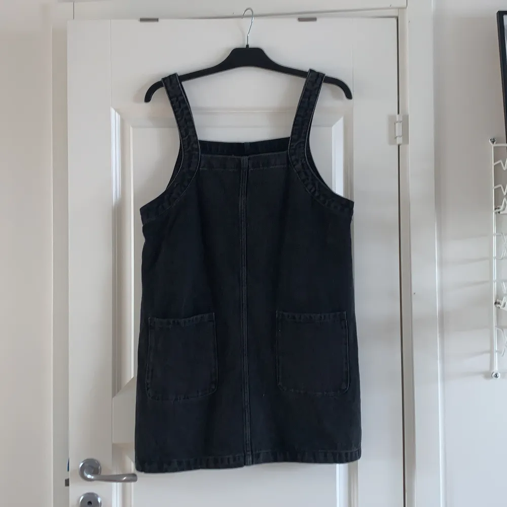 Fin svart jeans hängselklänning från Monki! Den är i storlek M och har en rak/lösare passform🥰. Klänningar.