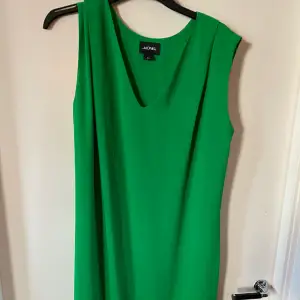 Fin grön festklänning i syntetmaterial. Har använts en hel del men färgen är fräsch fortfarande. Ganska rymlig, jag har storlek L och den har suttit bra på mig. 