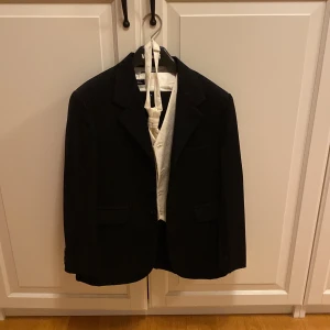 Mycket fin kostym t pojke - Använd endast en gång. Svart kostym, vit skjorta, vit väst och slips med glittrande paljetter. 