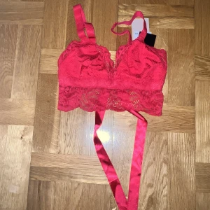 Bralette i spets - Bralette i spets i stl S, den är typ rosa/röd nästan en hot pink med röda toner. Aldrig använd finns även prislapp kvar. Har band bak så man kan göra rosett