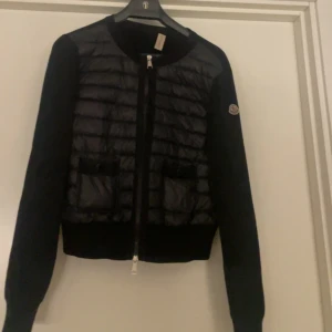 Moncler cardigan - Svart moncler cardigan äkta! Bra skick lite skador men syns ej och kan laga ett litet hål vid ärmen. Nypris ca 6000 skriv för mer bilder! Kom gärna med pris förslag!