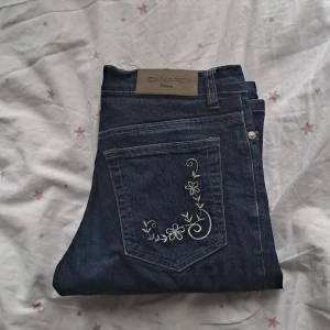 Jeans med broderi - Mörkblå jeans med broderi på fickorna. Storlek 36 och mid-waisted. Längden är bra på mig som är 165, men skulle nog bli lite förkorta till nån som är mycket längre än det. Fint skick.
