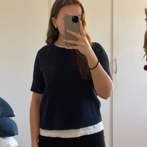 Marinblå stickad t-shirt  - Supersnygg, stilren marinblå stickad T-shirt från Nelly i storleken XS, passar även S. Använd några gånger men inga defekter.