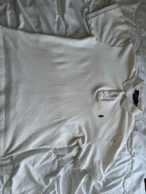 Ralph Lauren piké - Vit piké från Ralph lauren. Perfekt piké till sommaren. Pikén är storlek L men passar också storlek M. Den har en liten fläck vid axeln men de ska gå att få bort det med rätt tvätt medel.