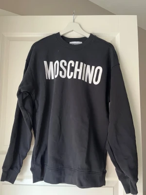 Moschino tröja - Använd fåtal gånger, kan inte se några tecken på användning. Kan inte se någon lapp med storlek men jag har Mi vanliga fall och passar mig men skulle även kunna passa någon med L. Köpt på Best secret och dom säljer endast äkta varor vad jag hört men har inge kvitto 