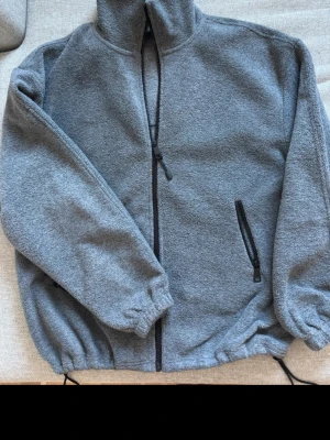 Fleece kofta/ tunn fleecejacka / mörkgrå - Perfekt tunn fleecejacka perfekt till våren eller sena sommarkvällar, jackan är i utmärkt skick trots användning men väldigt varsamt då det inte finns några tecken på användning. Den är väldigt mjuk i materialet och har en perfekt oversized fit. Nypris var 400kr