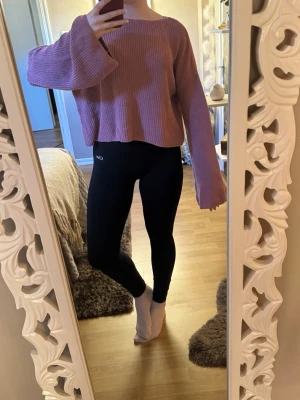 Rosa stickad tröja från NA-KD - Säljer en rosa stickad tröja från NA-KD i storlek L. Tröjan har en rak, lite boxig passform med långa ärmar och rund halsringning. Perfekt för lager-på-lager och chill dagar. Enkel och stilren design som funkar till det mesta.