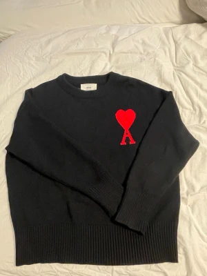 Svart tröja Ami Paris - Svart stickad ami Paris tröja med rött hjärta på högra bröstet med bokstaven A. Helt ny har inte använt.