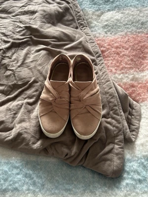 Rosa skor från ett okänd märke  - Ett par rosa skor från ett okänd märke med knutdetalj på toppen, en ganska hög sula men sköna inlägg. Perfekta nu till våren