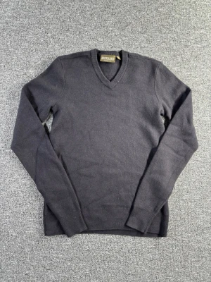 100% Merino Wool Sweater – Brokared – Size M - Stickad tröja i 100% merinoull från Brokared. Klassisk V-neck modell i mörk färg som passar perfekt till både casual och mer dressade outfits. Merinoull gör tröjan varm, mjuk och andas bra.  📏 Storlek: M 📐 Mått visas i bilderna ✨ Skick: Bra skick – se bilder för detaljer  Perfekt basplagg för höst och vinter.  💸 Följ mig så får du 10% rabatt på köpet!