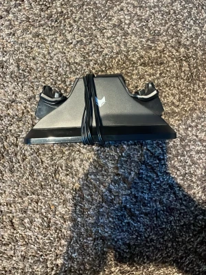Laddningsstation för PS4-handkontroller - Säljer en svart laddningsstation för PlayStation 4-handkontroller. Stället är gjort i plast och har plats för två kontroller samtidigt. Perfekt för att hålla dina DualShock 4-kontroller laddade och organiserade. Enkel att koppla in med medföljande kabel.