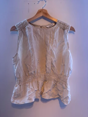 Beige volangkjol och blus från Kappahl  - Säljer en beige kjol från Kappahl med volangdetaljer och smock i midjan. Även en blus. De passar perfekt tillsammans som ett set.