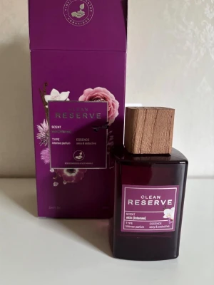 Clean Reserve Skin Intense Parfym limited edition 100ml  - En lyxig parfym från Clean Reserve i doften Skin [Intense]. Flaskan är mörklila med en elegant träkork och etikett i lila och vitt. Kommer i en snygg lila kartong med blommotiv. Parfymen har en sensuell och förförisk doftprofil.