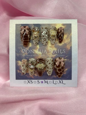 SweetLeo (M);Medium Almond - Unika handgjorda press-on naglar i bruna och beige toner med leopardmönster, 3D rosetter och sanrio charms dekorationer. Naglarna har en medium lång, mandel form och är i M: 16 mm, 12 mm, 12,5 mm, 11,5 mm, 10 mm . Perfekt för dig som vill sticka ut med coola detaljer.