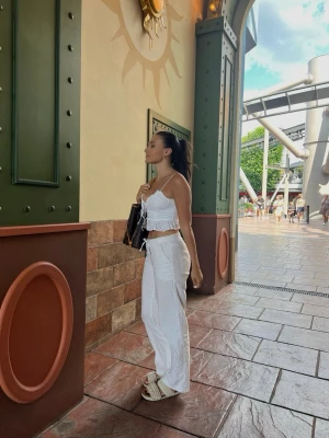 Söt topp med broderidetaljer - Croppad söt topp i benvit färg med broderidetaljer från Forever 21 i storlek S. Justerbara axelband och knyt framtill.  Använd men i gott skick.